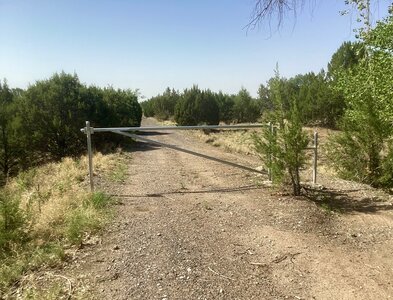 A gate with a pedestian pass-through along the old railroad grade trail.