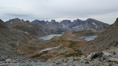Looking to the west side of the Continental Divide from Photo Pass. Bewmark Lake (left) and Lake 11921 (right) are nearby at the foot of the pass, with many rugged peaks in the distance.