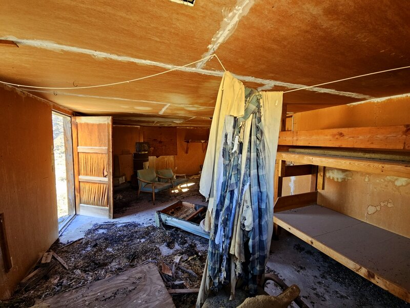 Inside the old cabin looking in a window from the outside.
